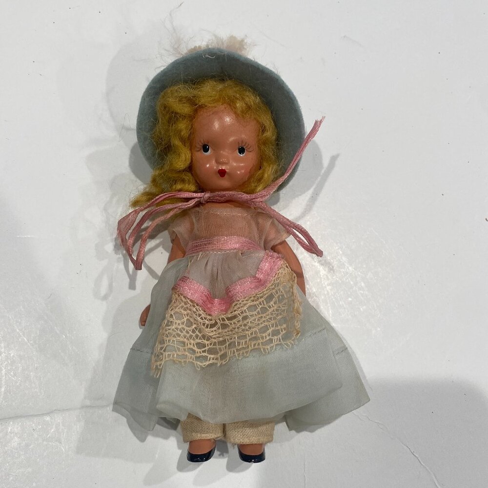 Vintage Nancy Ann Storybook doll with articulating arms in blue and pink.